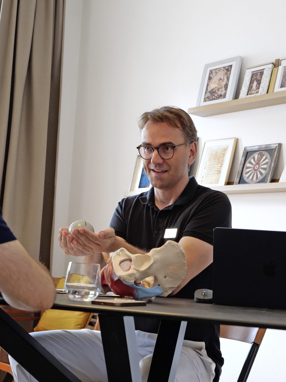Daniel Klafke erklärt einem Kunden am Beckenmodell den Beckenboden