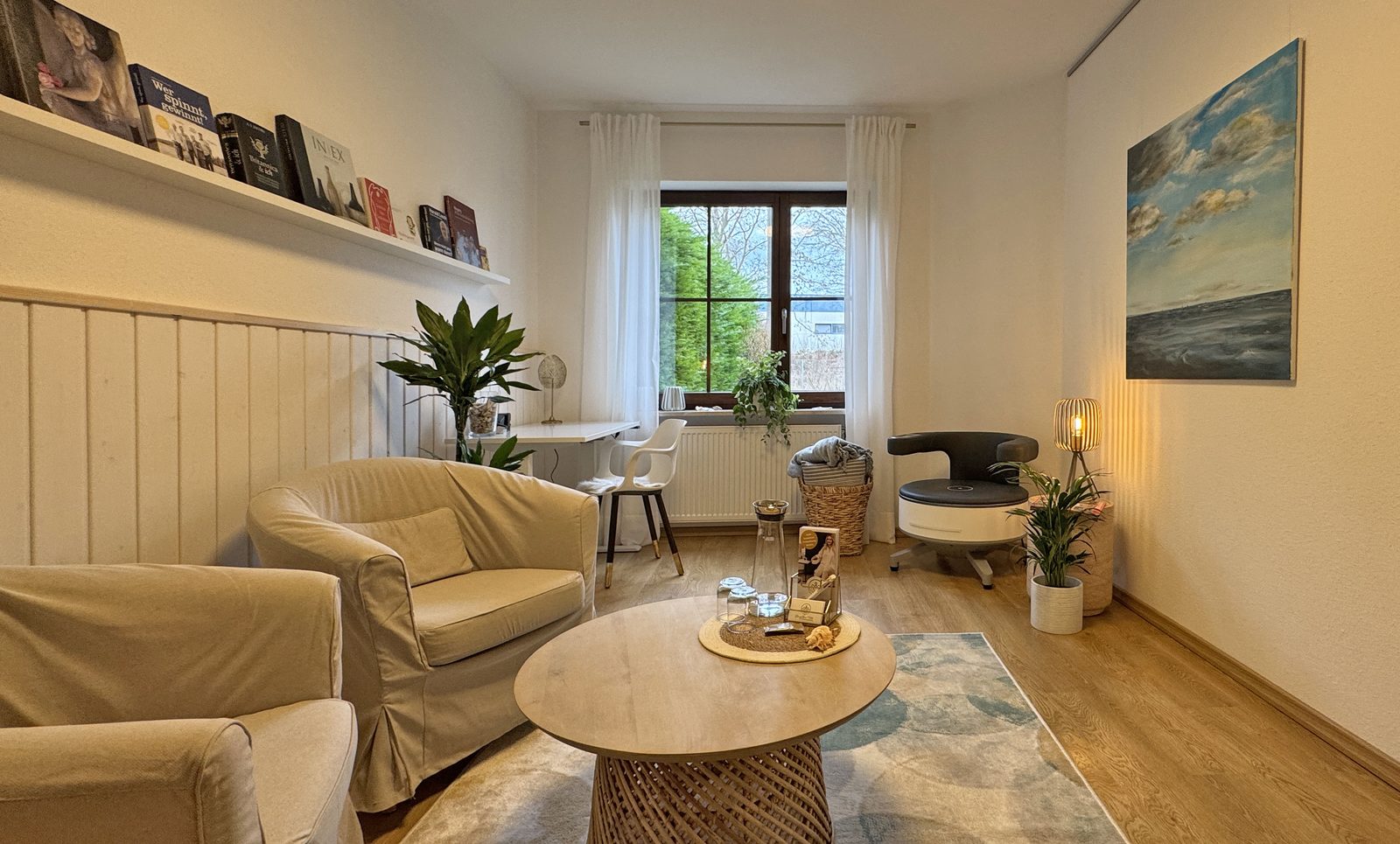 Gemütlicher Studioraum mit Sofa, Sessel und Couchtisch